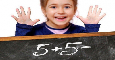 dziecko tablica i napis 5 plus 5